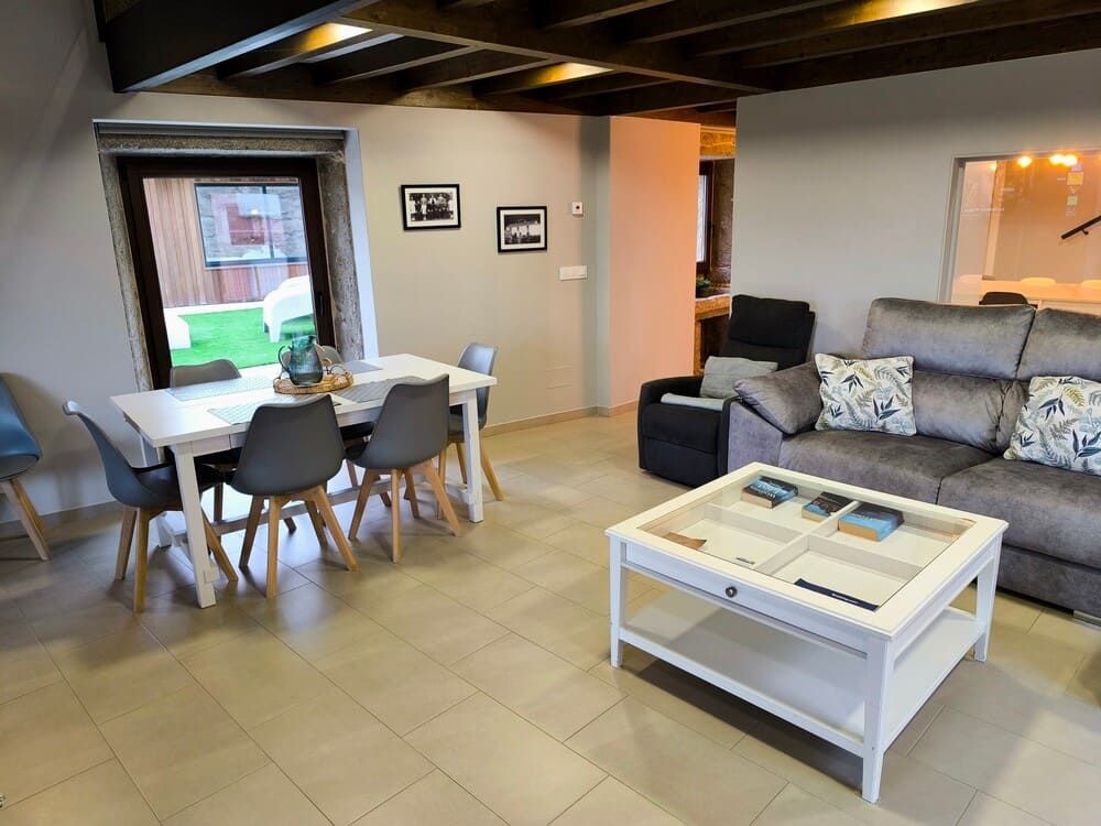 Una sala de estar con sofá, mesa y sillas.