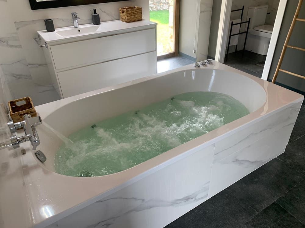 Una bañera llena de agua verde en un baño.