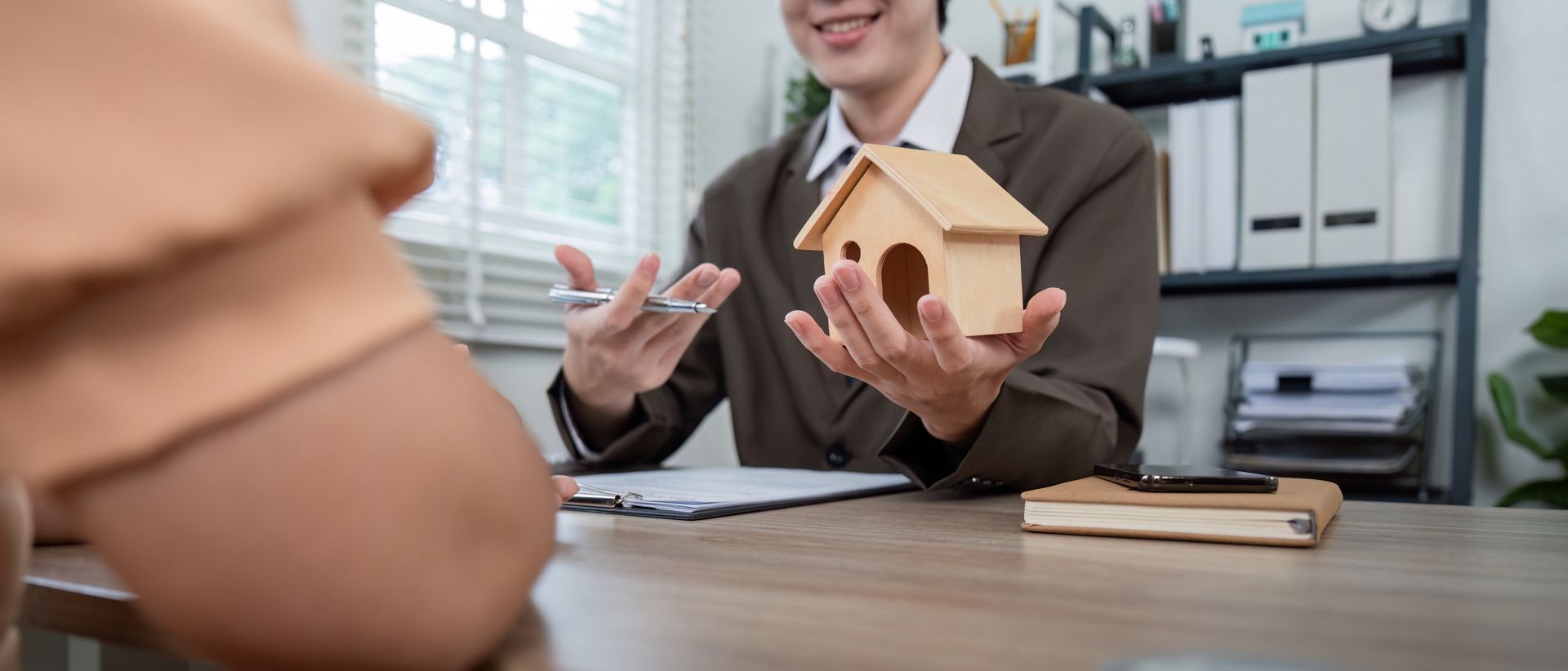Un expert immobilier présente une petite maison en bois