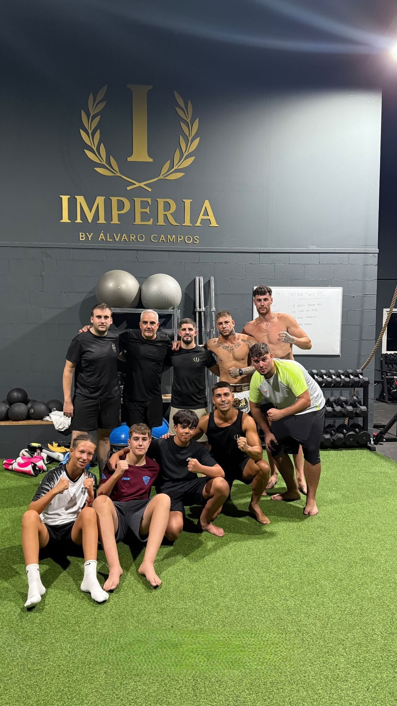 Un grupo de personas posando para una foto en un gimnasio con el logotipo de 