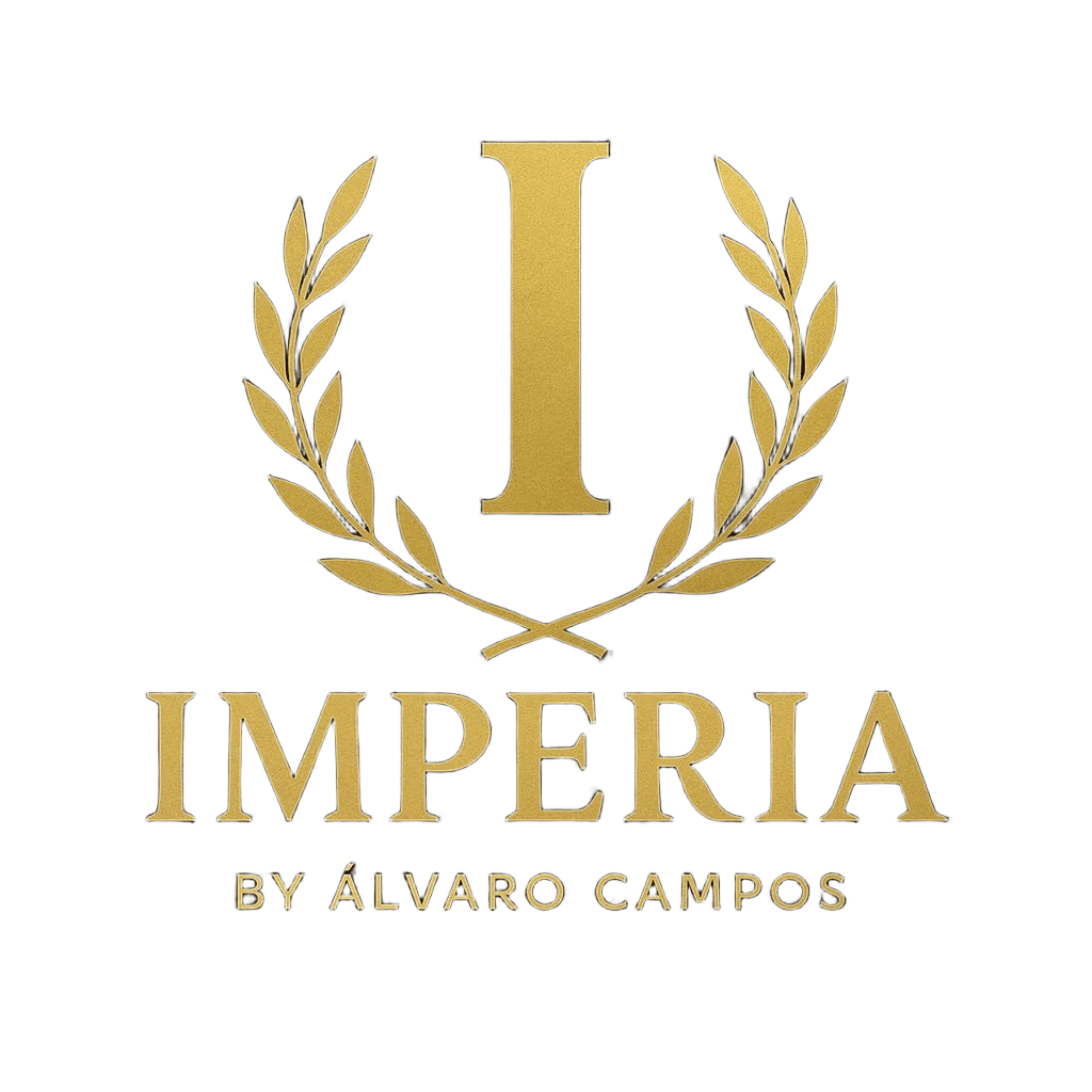 Logotipo dorado con una gran letra "I" enmarcada por espigas de trigo, con la inscripción "IMPERIA BY ÁLVARO CAMPOS"