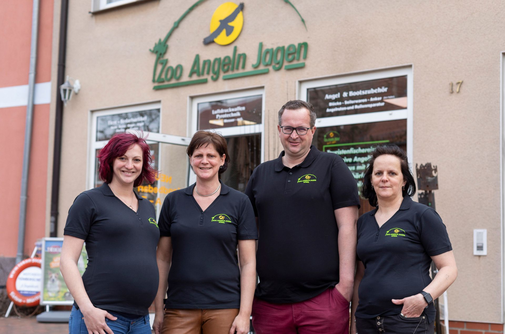 Eine Gruppe von Menschen posiert vor einem Zoo für ein Foto.