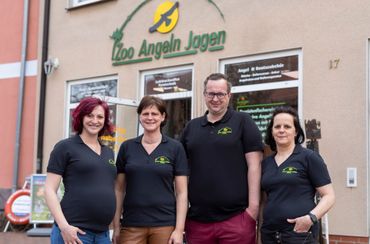 Eine Gruppe von Menschen posiert vor einem Zoo für ein Foto.