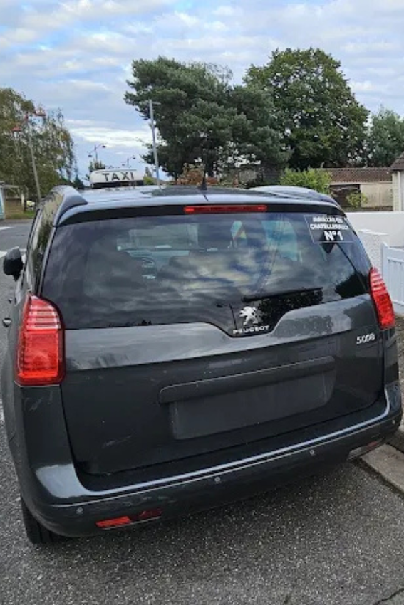 Une voiture noire est garée sur le bord de la route.