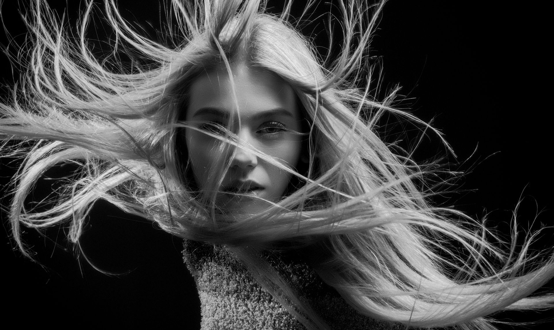 Una fotografía en blanco y negro de una mujer con cabello largo y rubio ondeando al viento.
