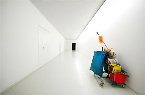 Un carrito de limpieza está en medio de un pasillo.