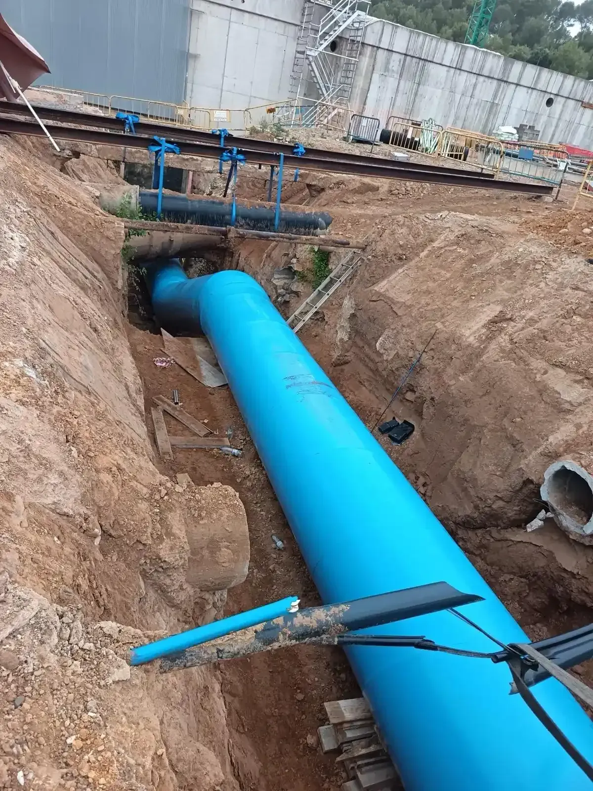 Tubería de color azul brillante tendida en una zanja en una obra de construcción,