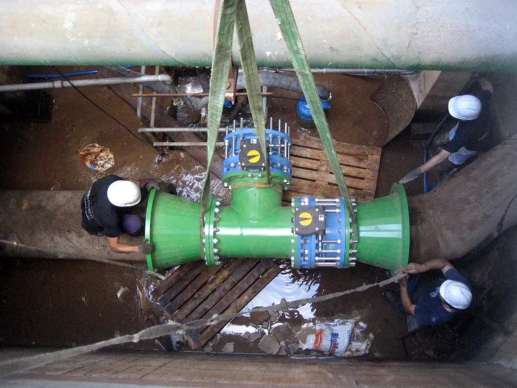Conjunto de tuberías industriales verdes en un foso, suspendido por correas