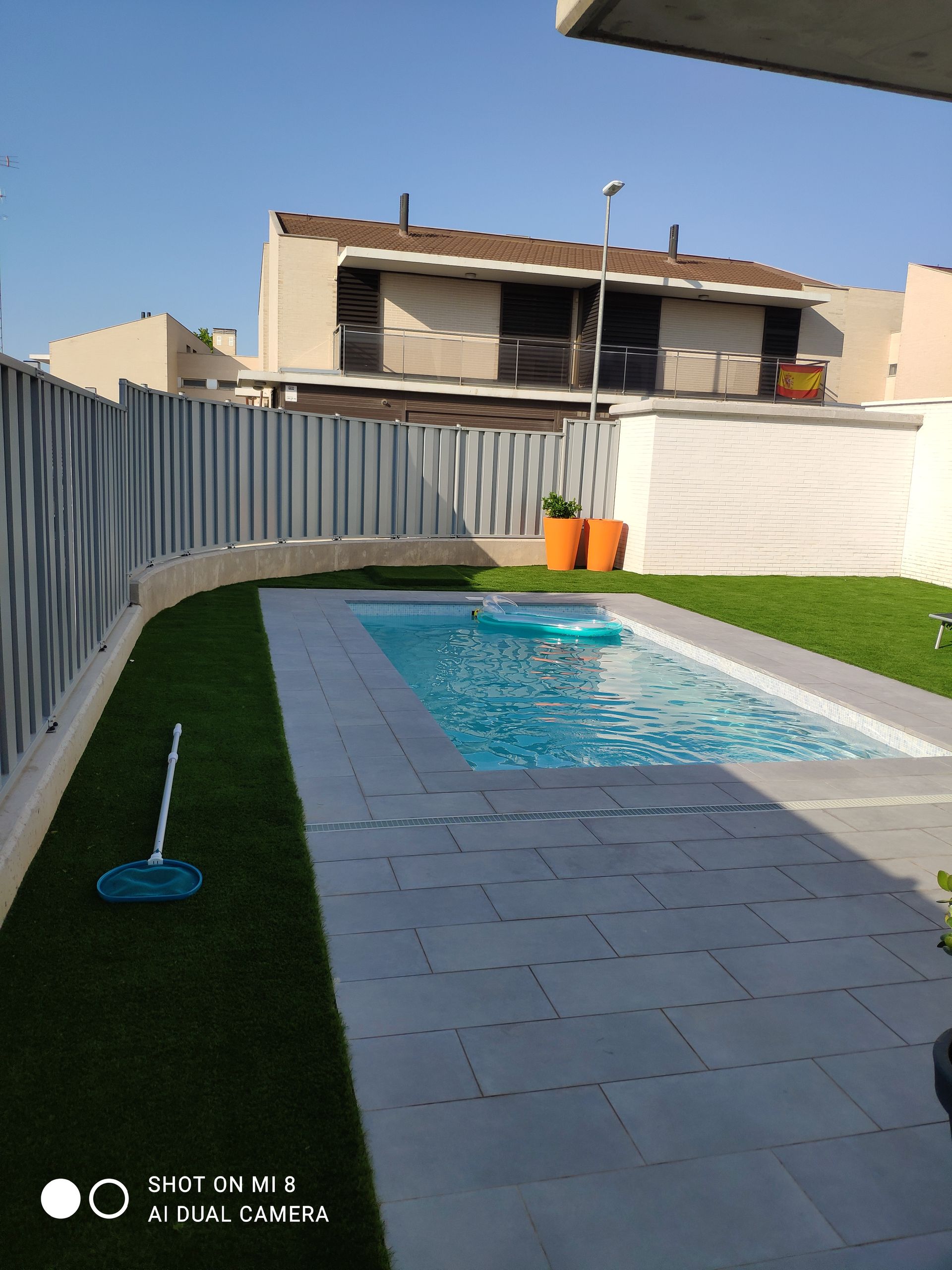 Una piscina está en el patio trasero de una casa