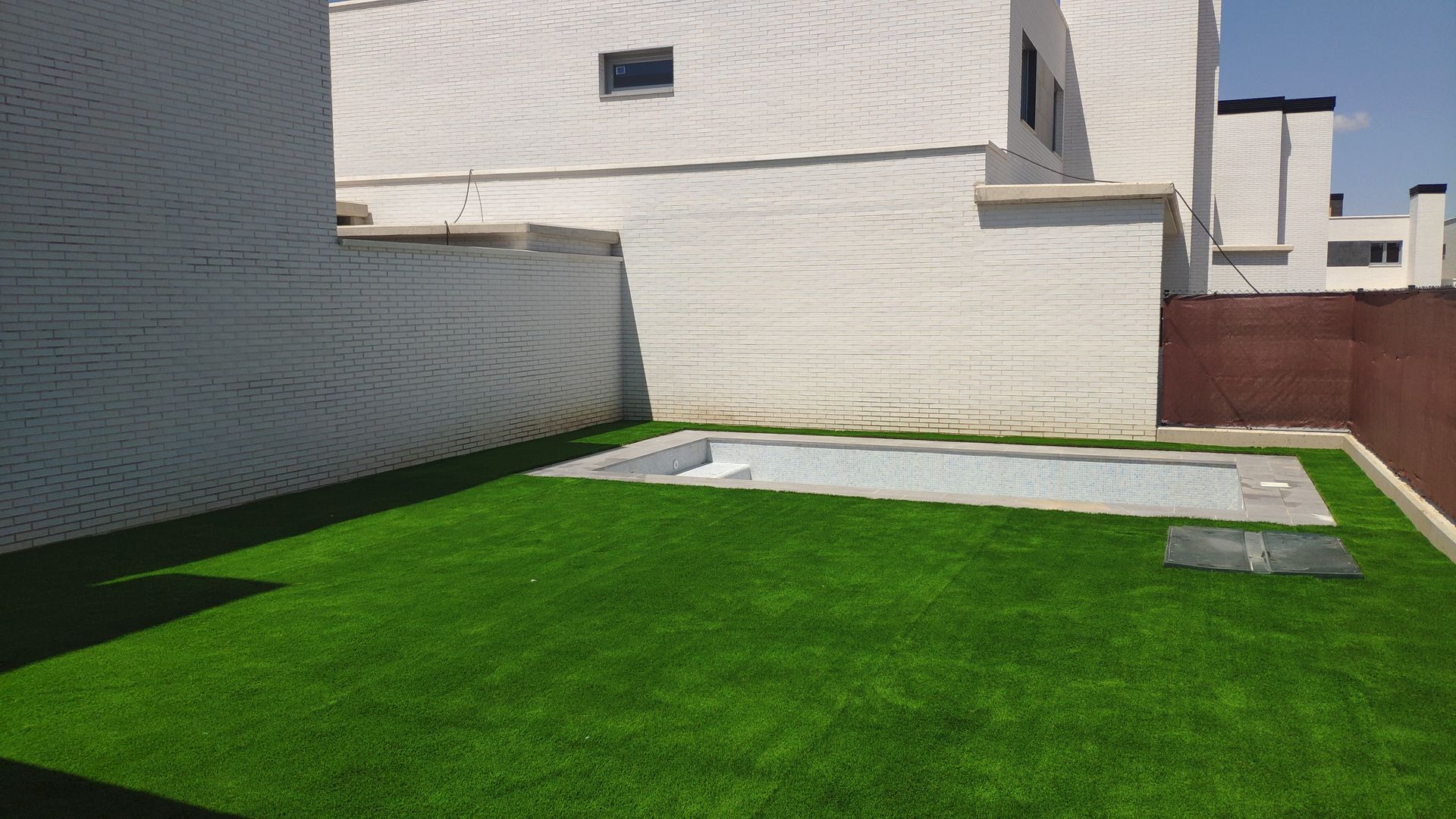 Hay una piscina en el patio trasero de una casa.