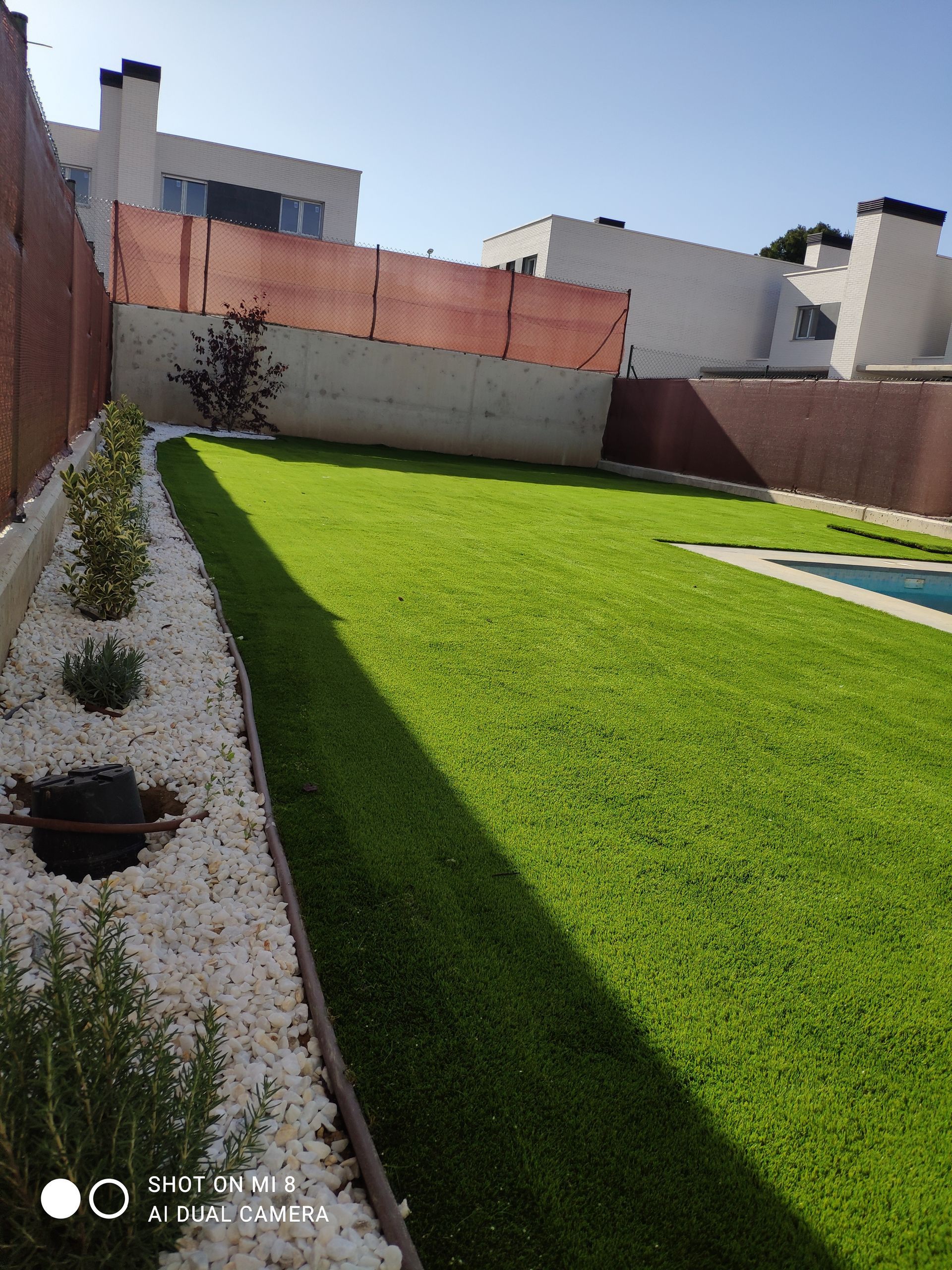 Un patio trasero con valla y piscina.