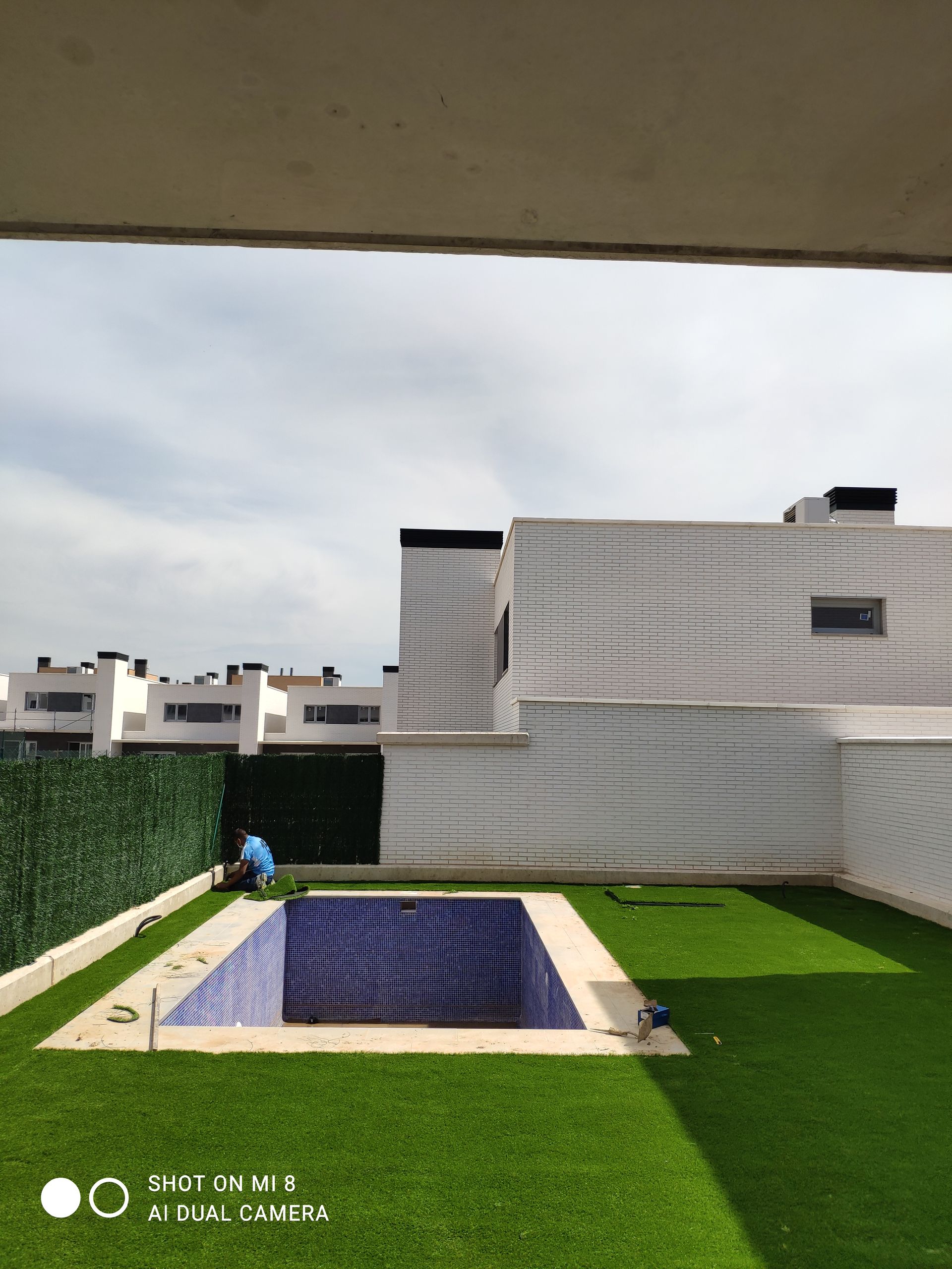 Una gran casa blanca con una piscina delante de ella.