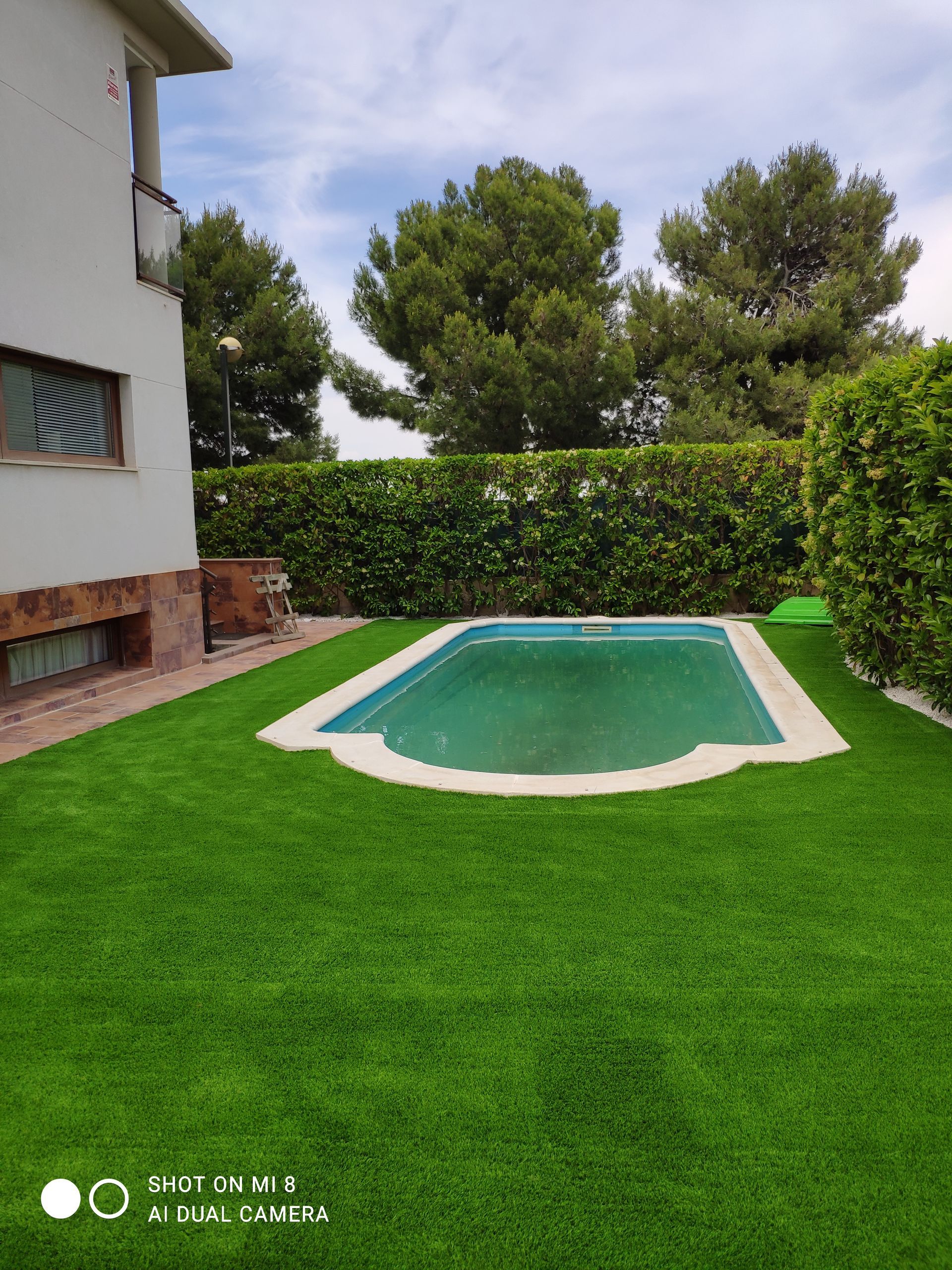 Hay una piscina en el patio trasero de una casa.