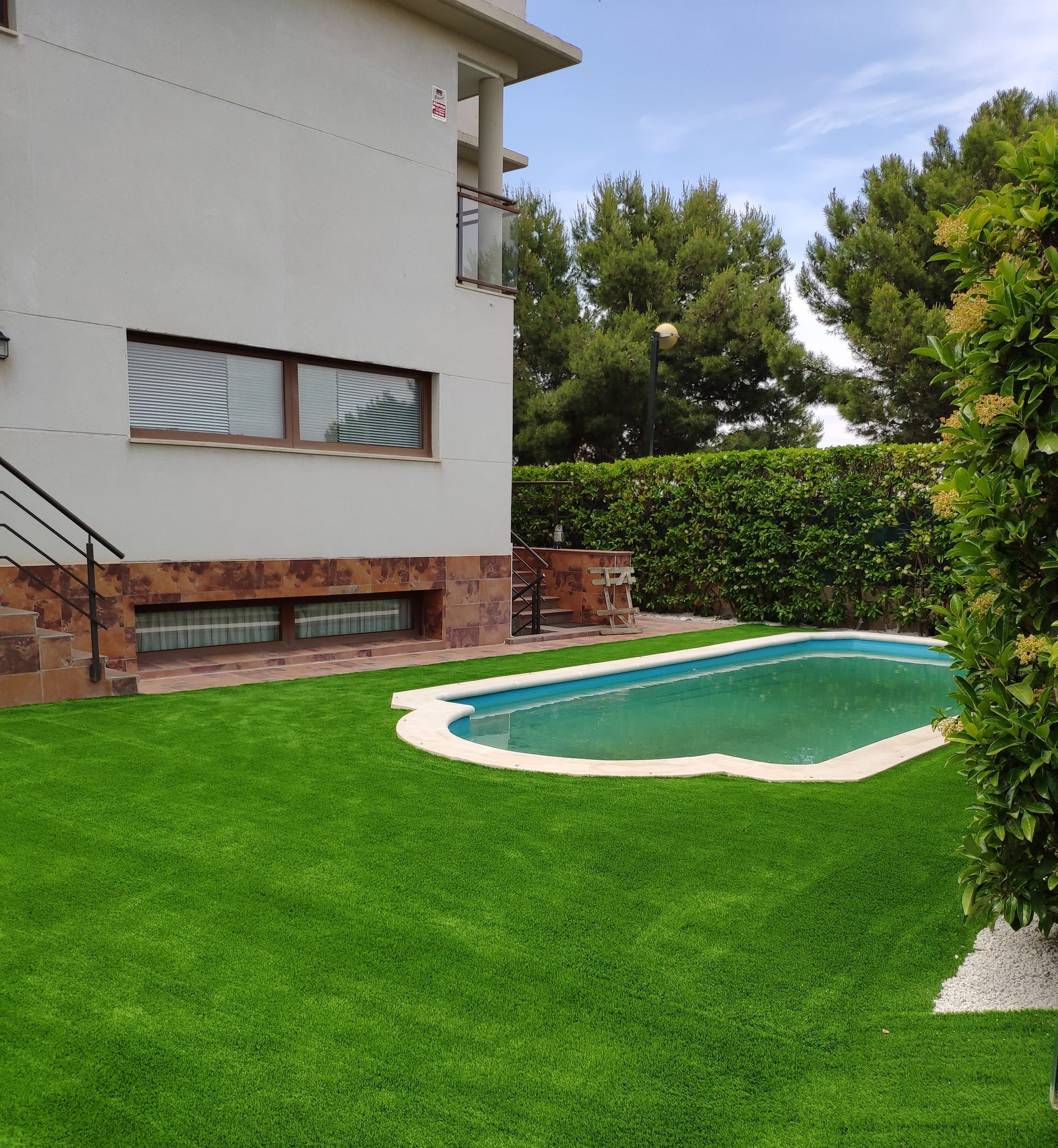Una casa blanca con una gran piscina delante de ella.