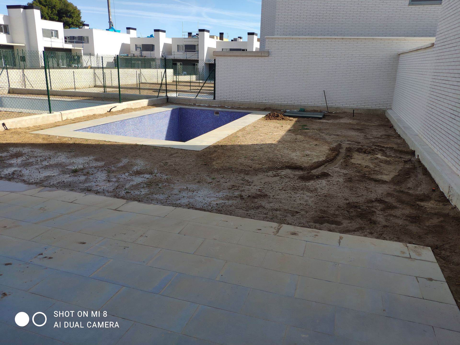 Se está construyendo una piscina en el patio trasero de una casa.
