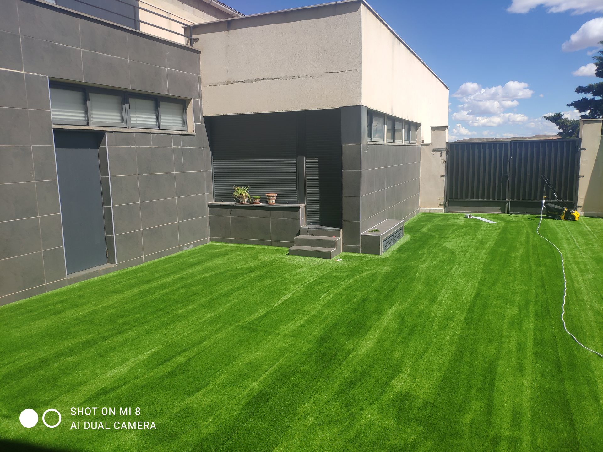 Una casa con un exuberante césped verde en frente de ella.