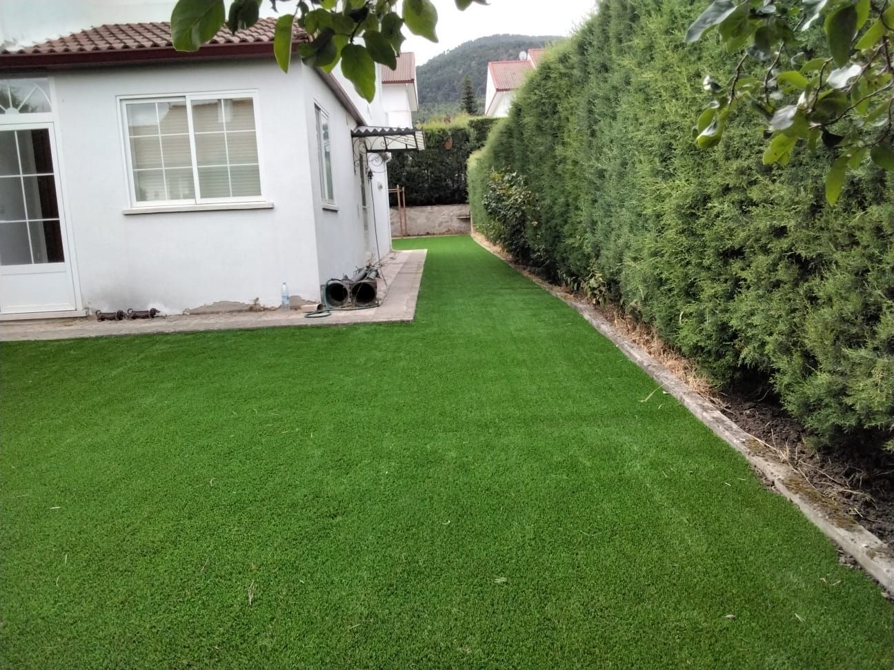 Una casa blanca con un exuberante césped verde frente a ella.