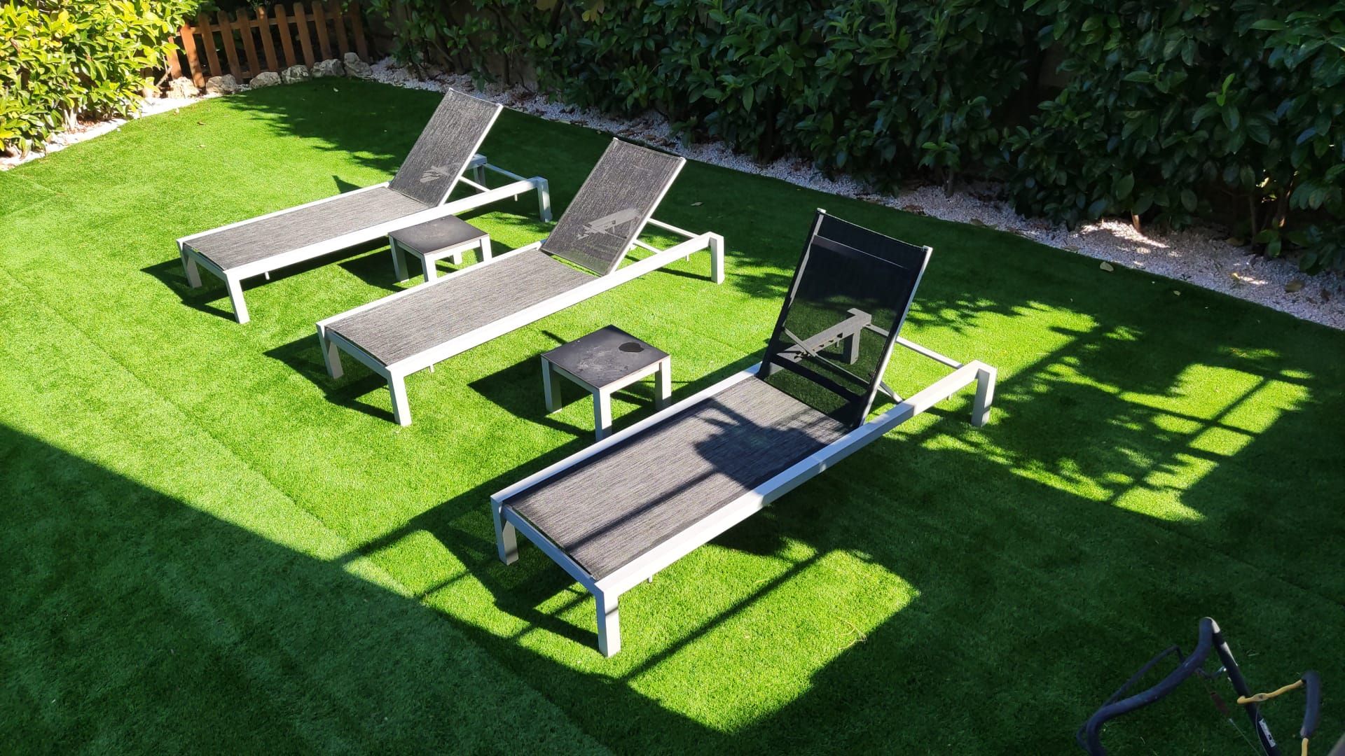 Tres sillones se encuentran sobre un exuberante césped verde.