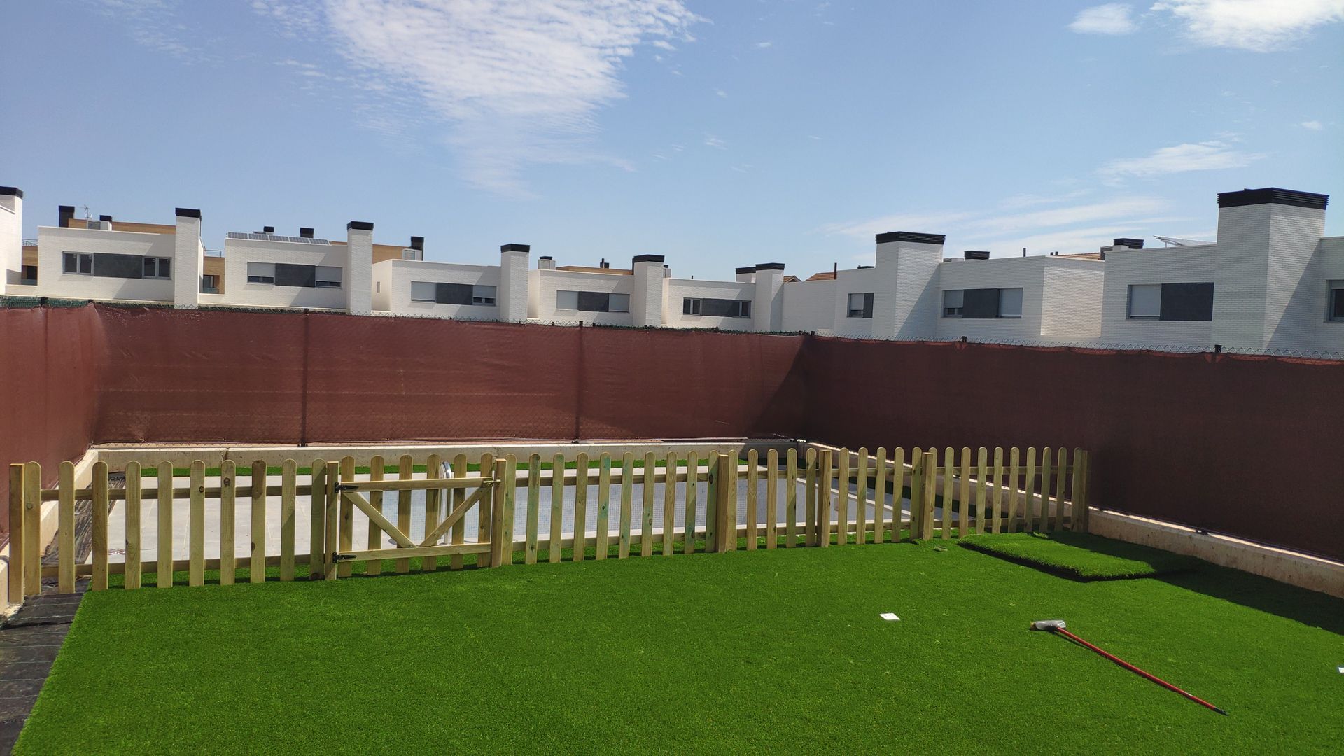 Una valla de madera rodea un exuberante césped verde.