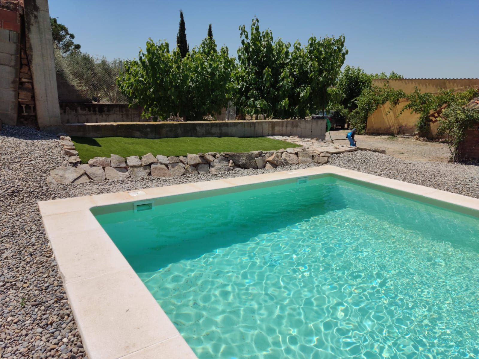 Una gran piscina con árboles al fondo.