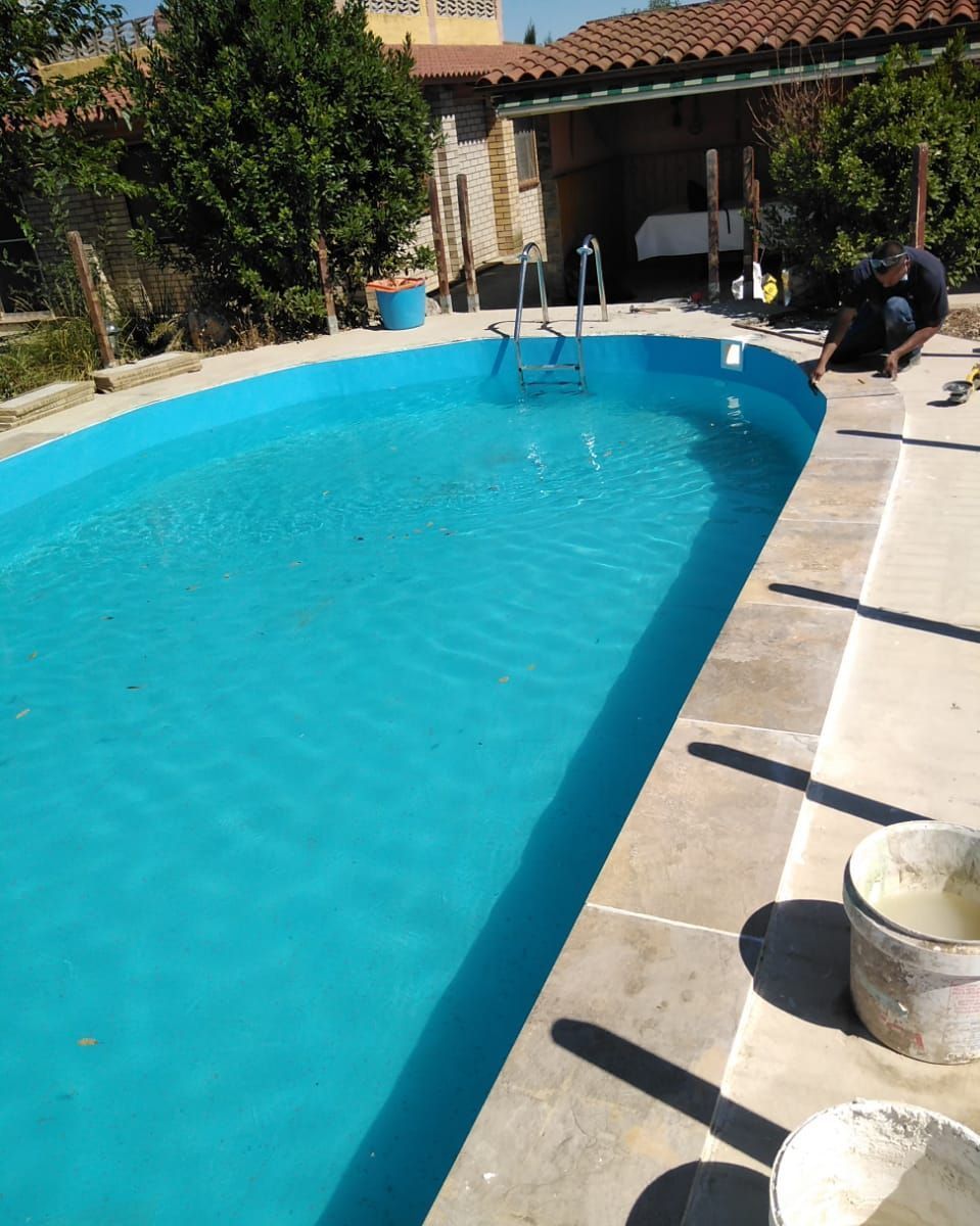 Una gran piscina azul con una escalera en ella.