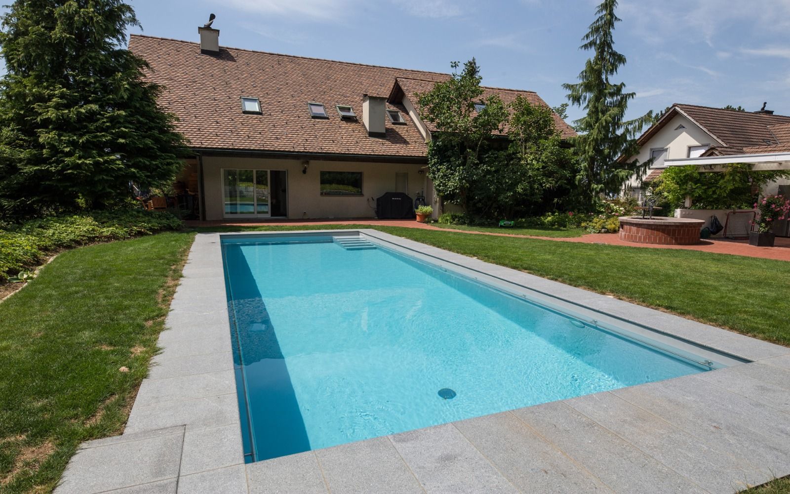 Una gran piscina en el patio trasero de una casa
