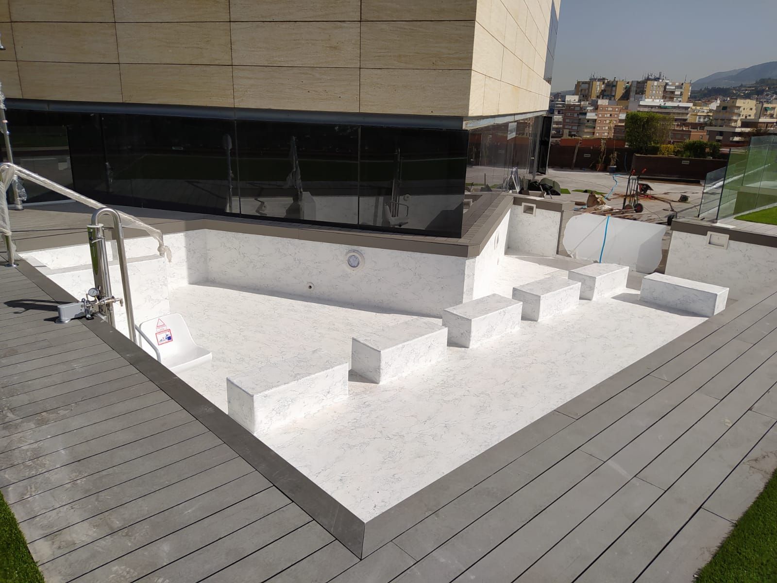 Una gran piscina blanca con escaleras que conducen a ella.