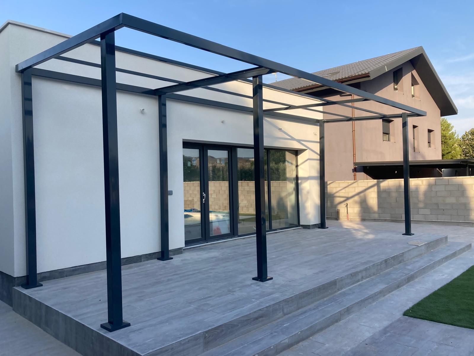 Hay una pérgola en el costado de una casa.