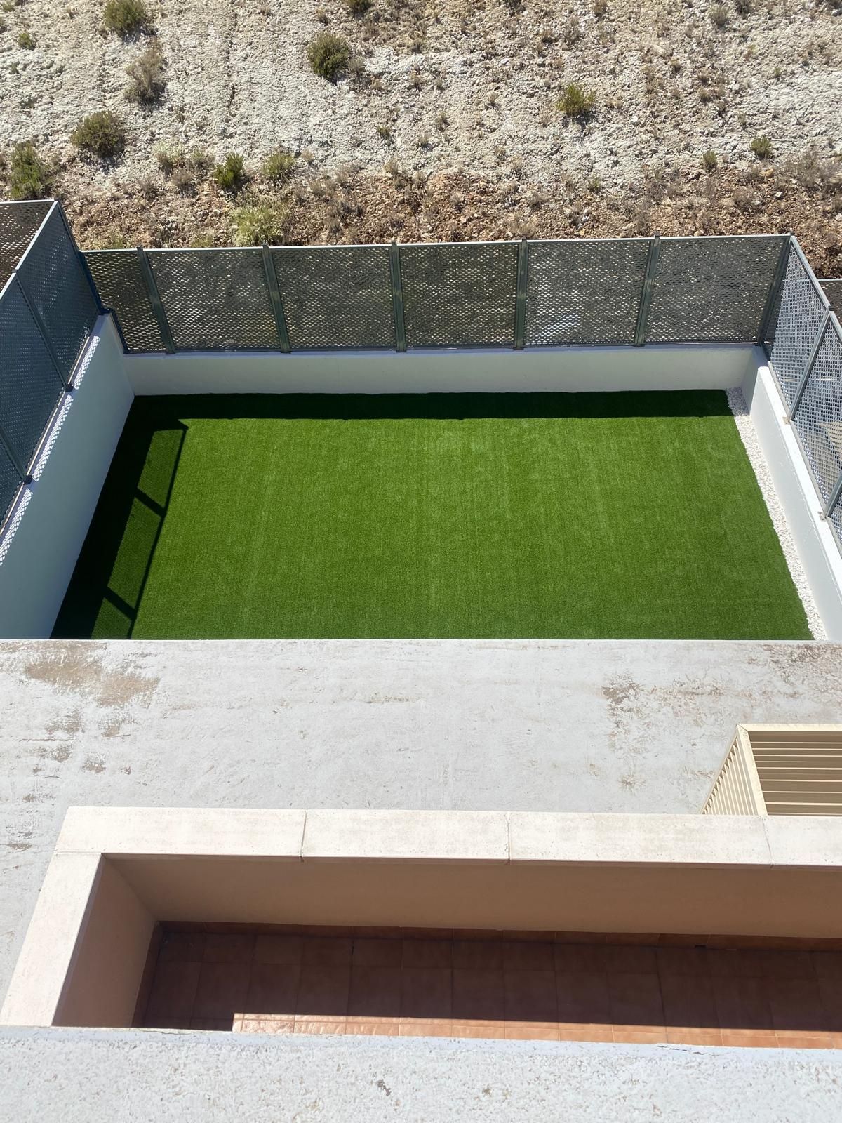 Una vista aérea de un patio con valla y césped.