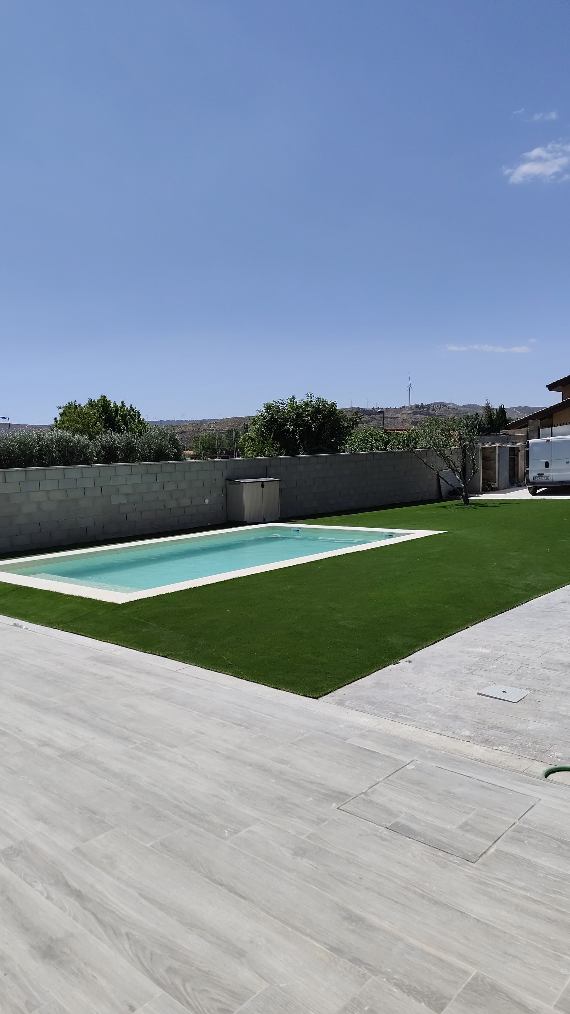 Una gran piscina está rodeada de un exuberante césped verde.