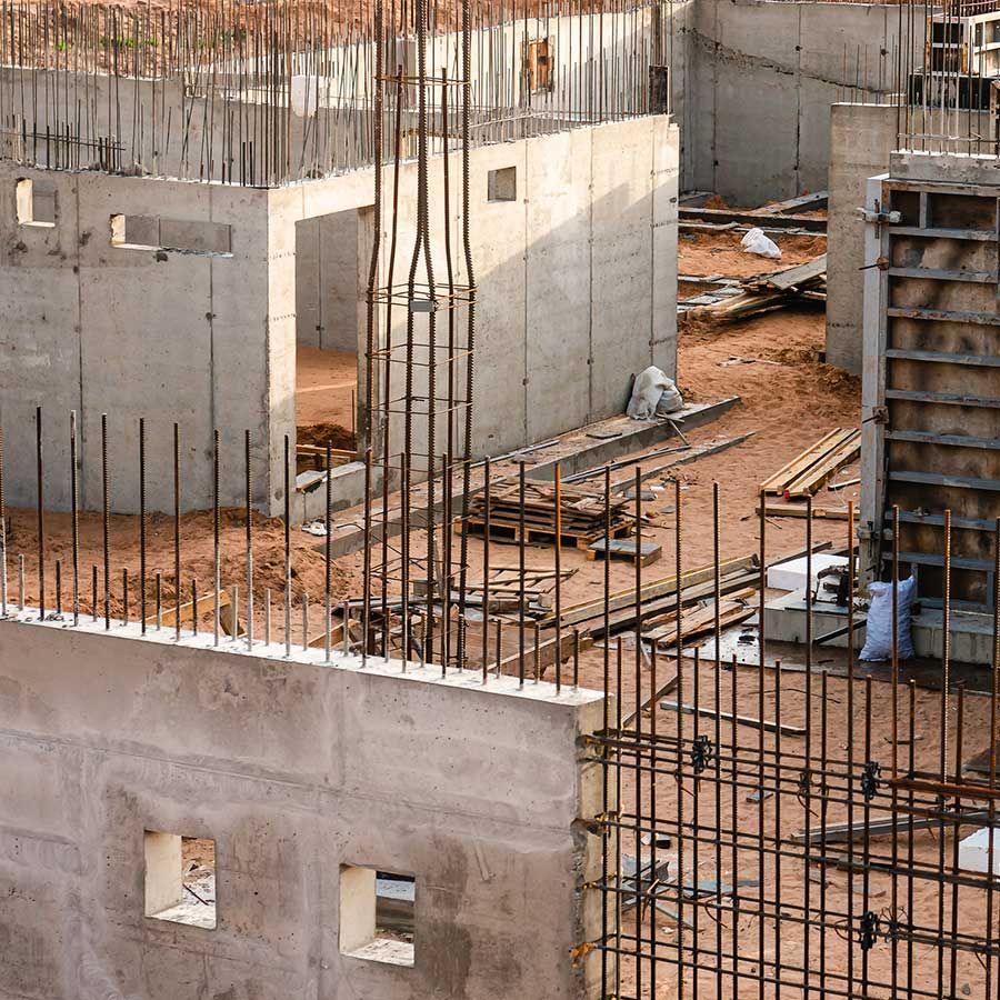 Una obra en construcción con paredes de hormigón y una valla metálica.