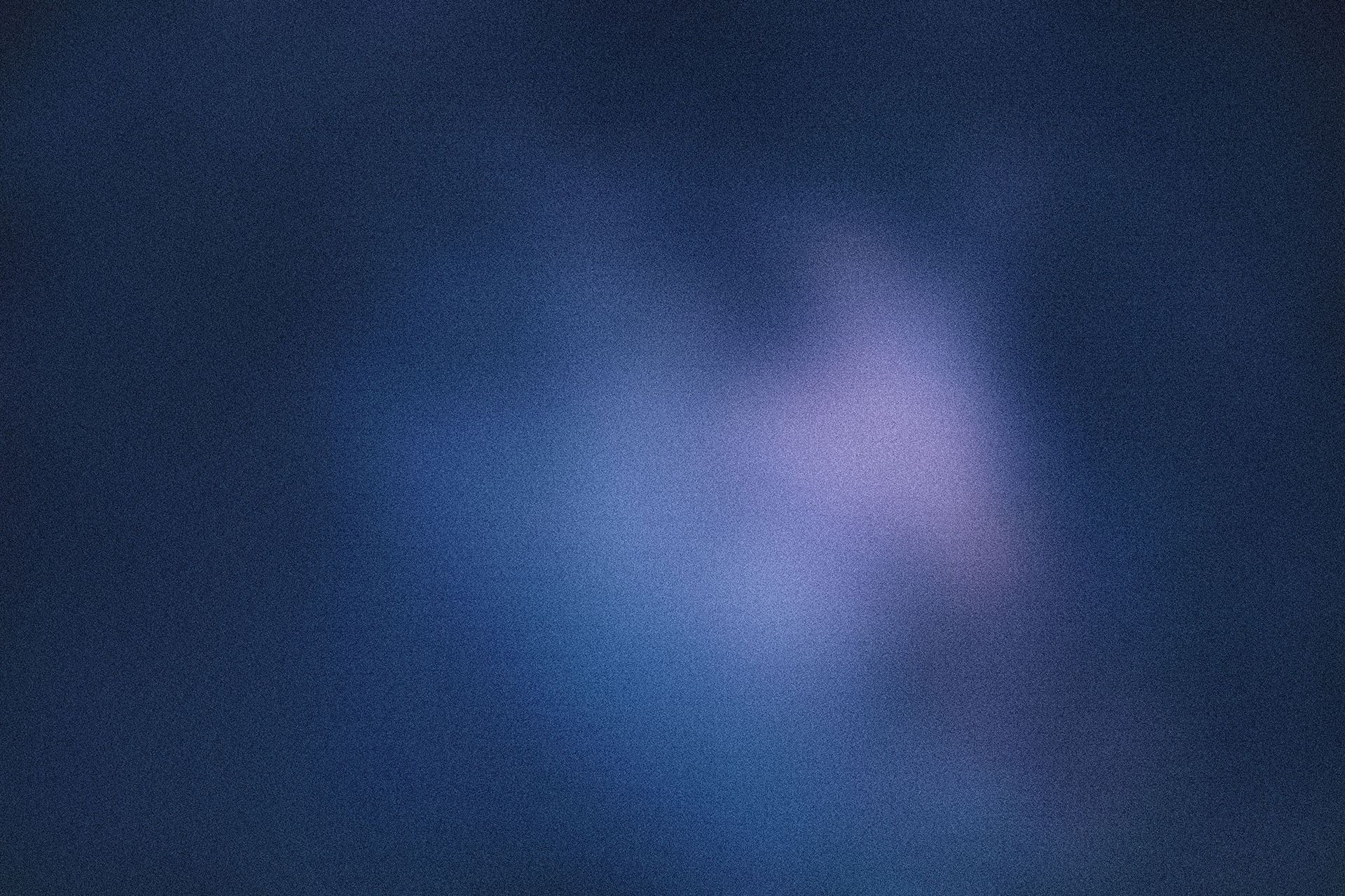 Bläulich getönter, körniger Hintergrund mit einer hellen, verschwommenen, violett getönten Form in der Mitte.