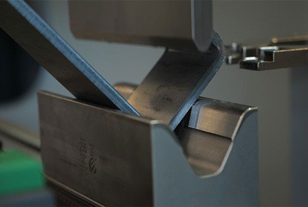 In einer Fabrik steht eine große Maschine, die von einem Zaun umgeben ist.