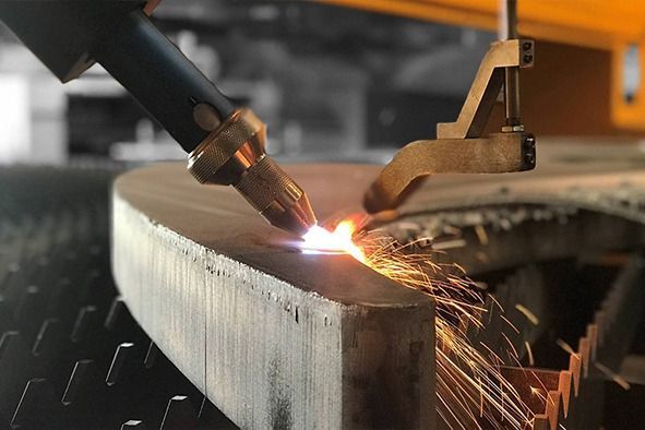 Eine Maschine schneidet mit einem Brenner ein Stück Metall.