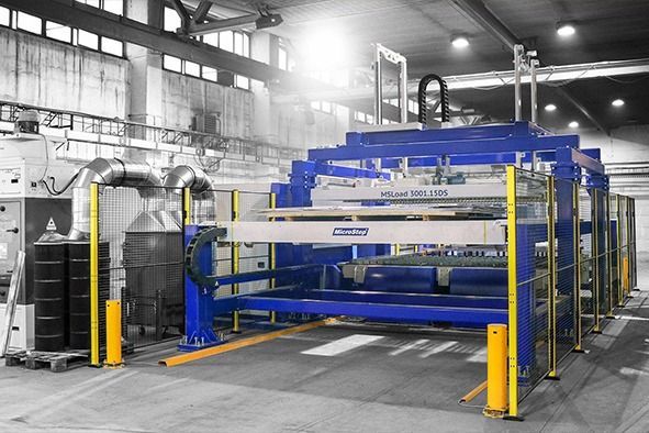 In einer Fabrik steht eine große Maschine, die von einem Zaun umgeben ist.
