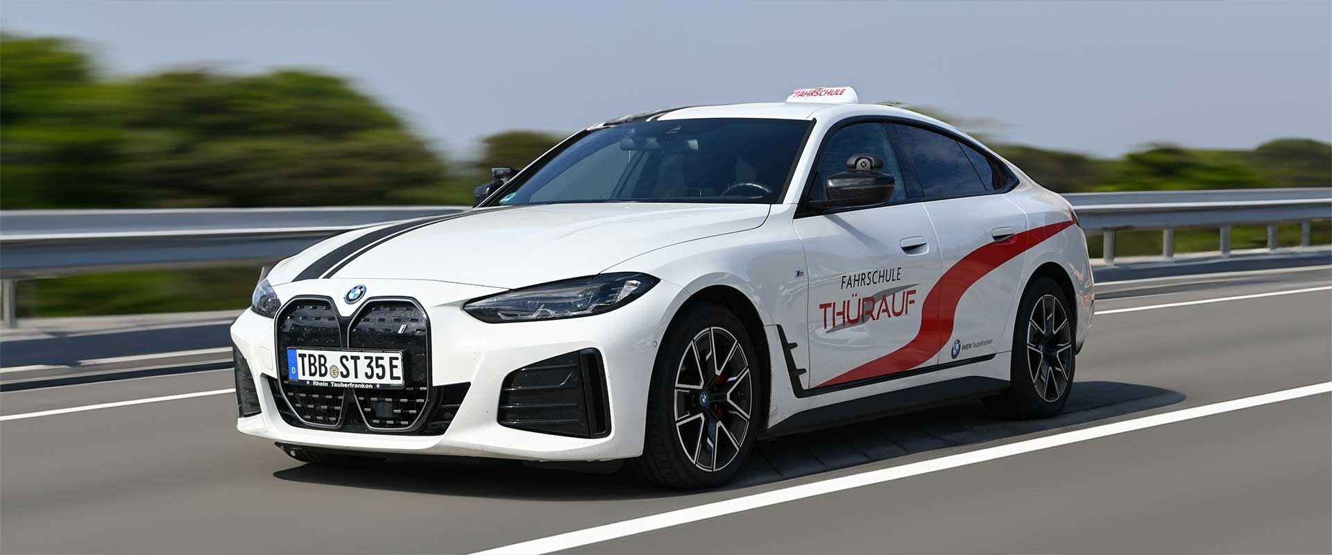 Ein weiß-roter Sportwagen fährt auf einer Autobahn unter klarem Himmel