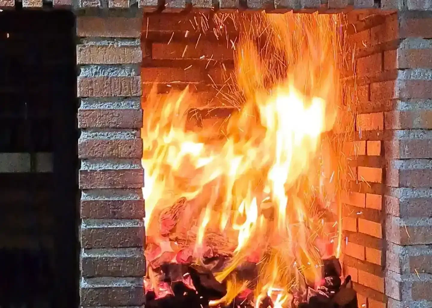 Barbacoa argentina con carnes a la parrilla, chimichurri y llamas en una parrilla rústica.