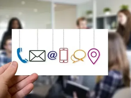 Una persona sostiene una tarjeta con íconos de contacto.