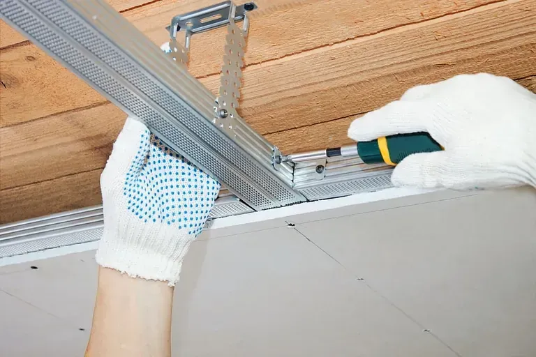 Una persona está trabajando en un techo con un destornillador.
