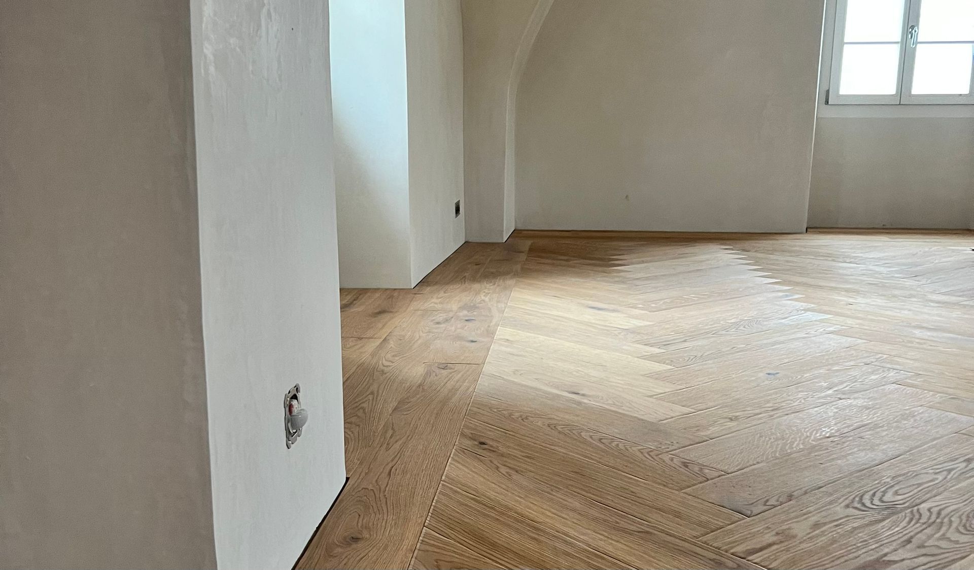 Bärtsch & Söhne AG, Wohnzimmer mit dunkelgrüner Couch, Tisch in dunklem Holz, Wand in Maueroptik