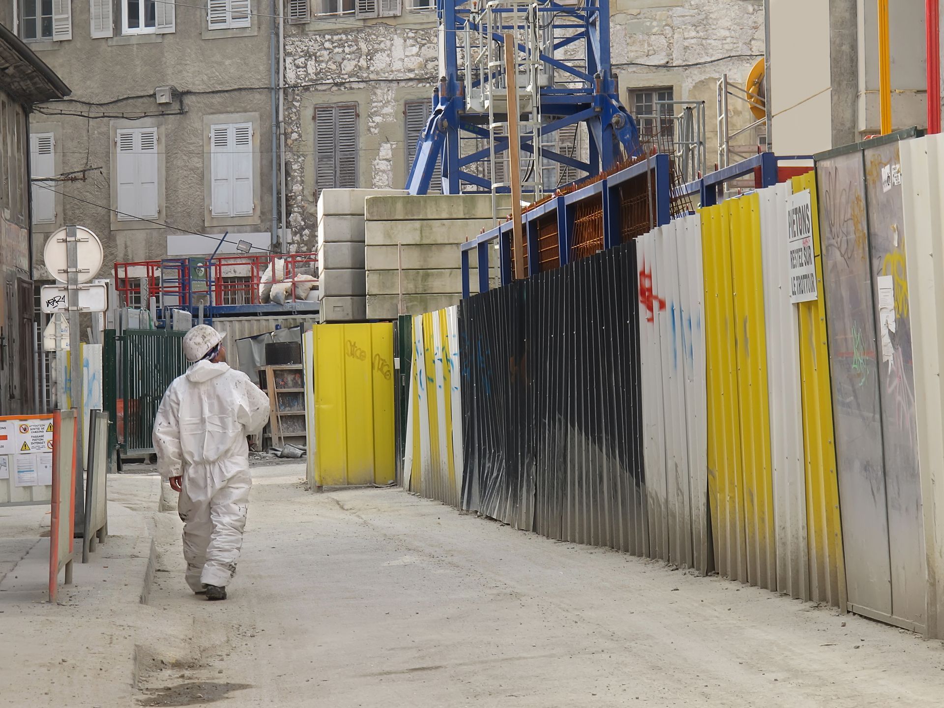 Homme en tenue de protection marchant près d'un chantier industriel