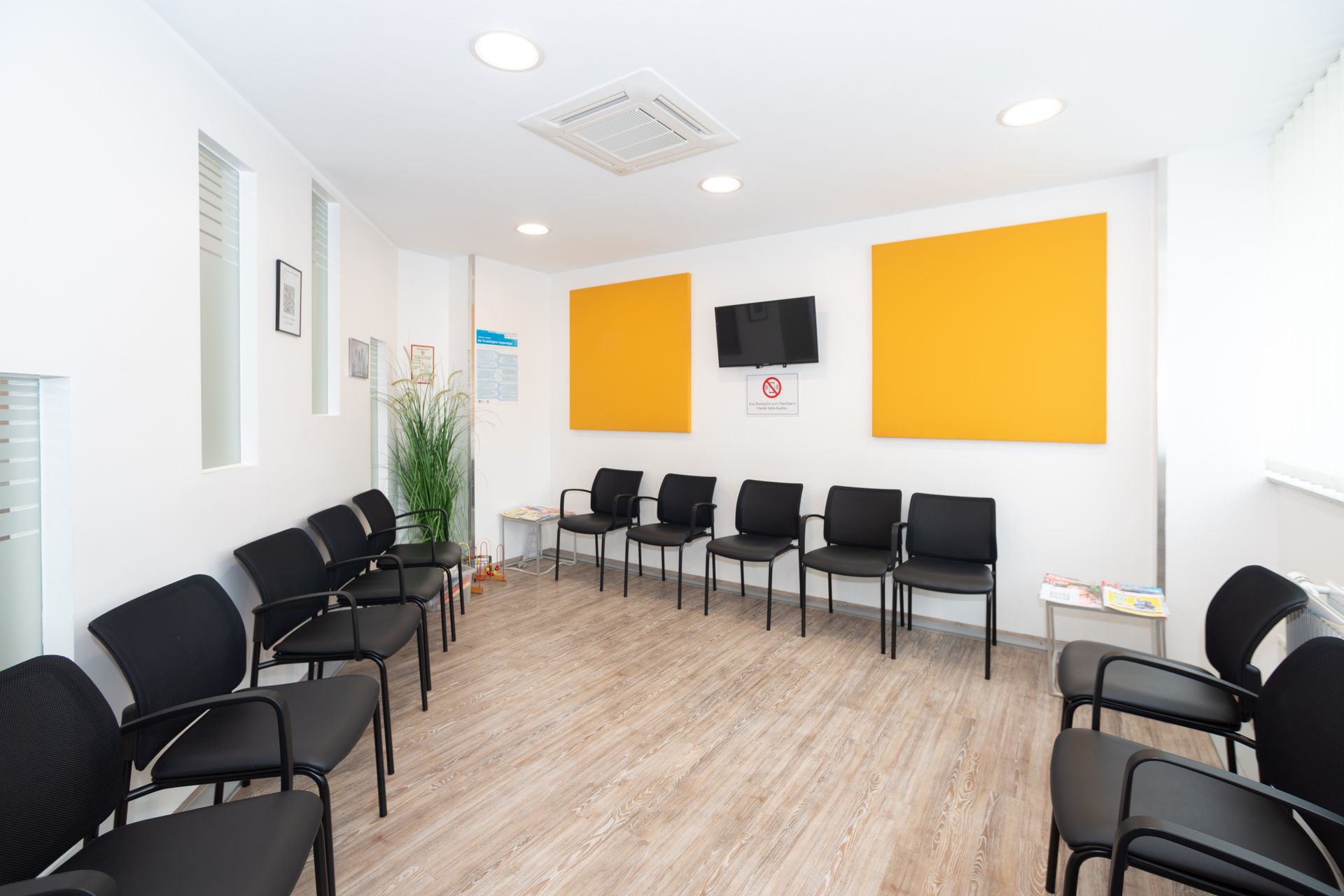 Eine Darstellung einer Arztpraxis mit Schreibtisch und Stühlen.