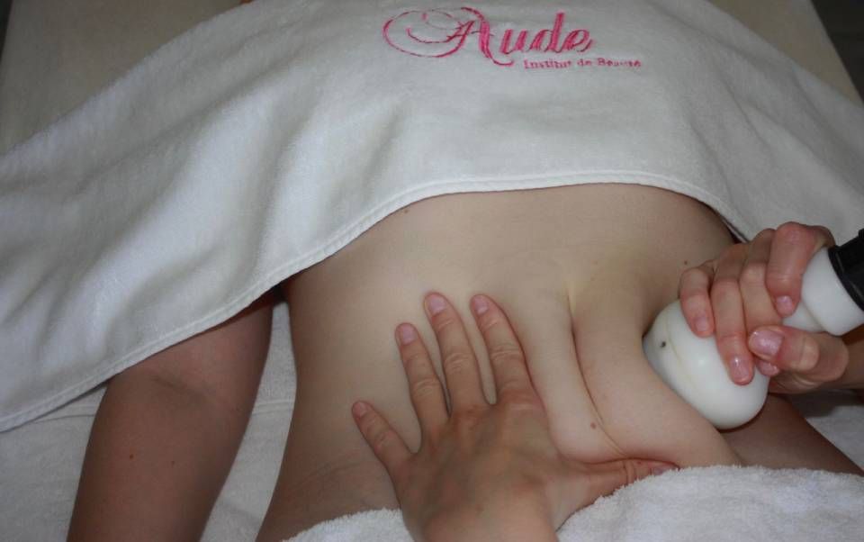 Des mains effectuent un massage corporel sur le dos d'une personne.