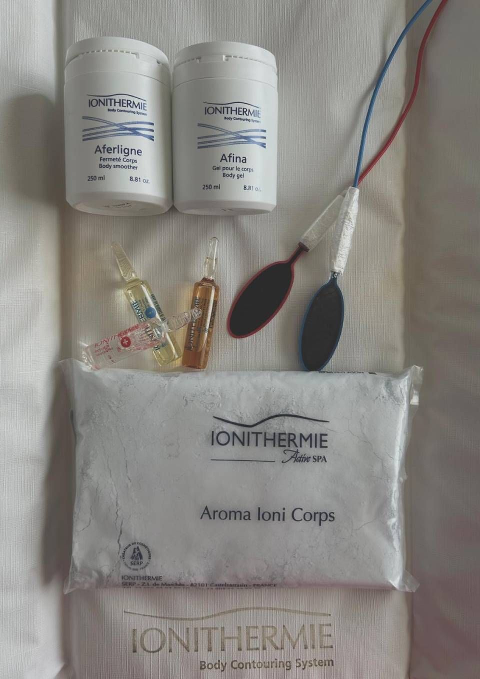 Kit d'enveloppement corporel Ionithermie comprenant des poudres, des ampoules, des électrodes et un enveloppement corporel.