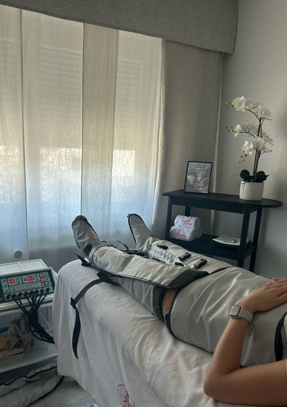 Personne recevant une thérapie par compression des jambes sur un lit de traitement.