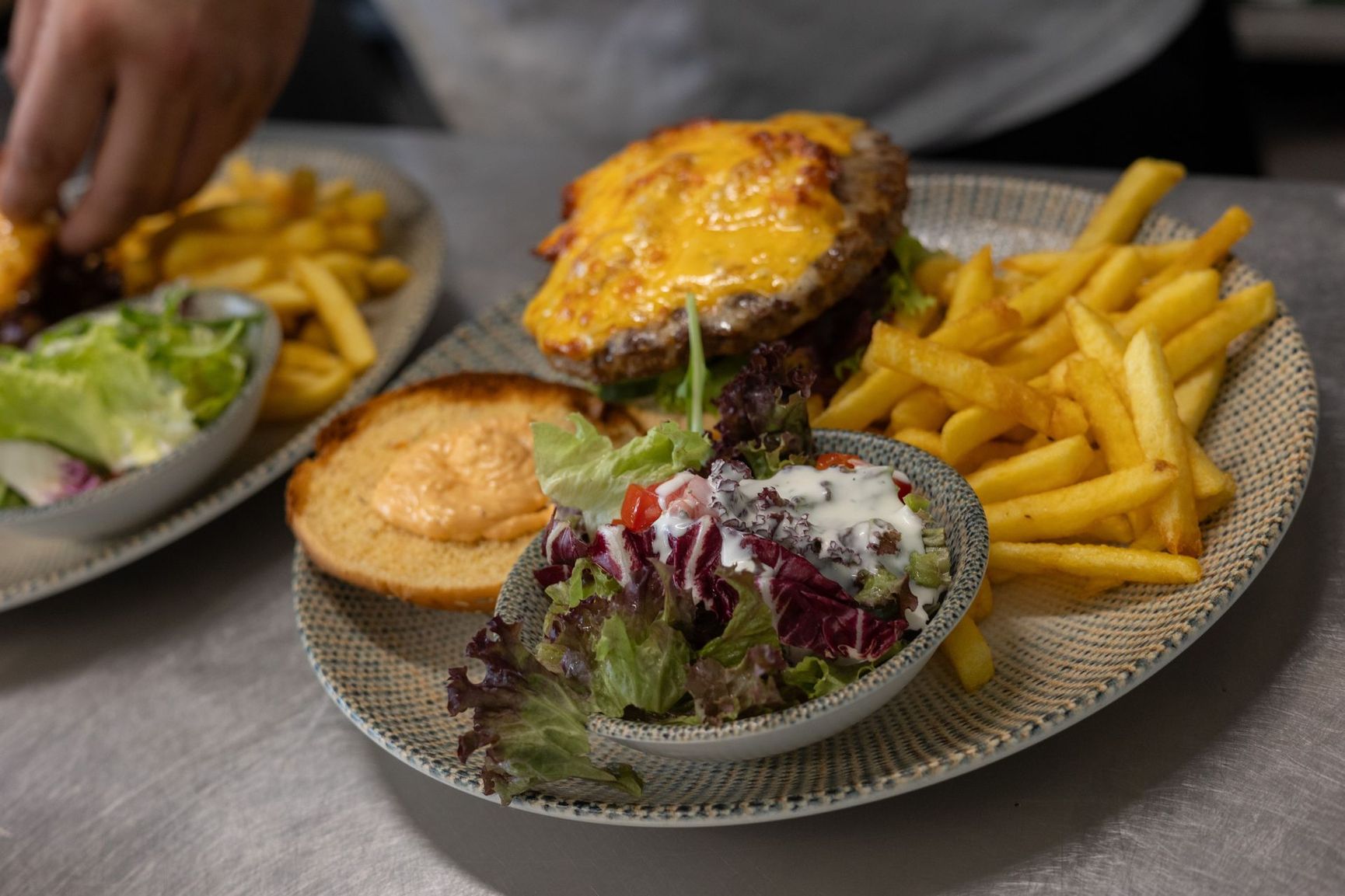 Ein Hamburger mit Pommes Frites und Salat auf einem Teller