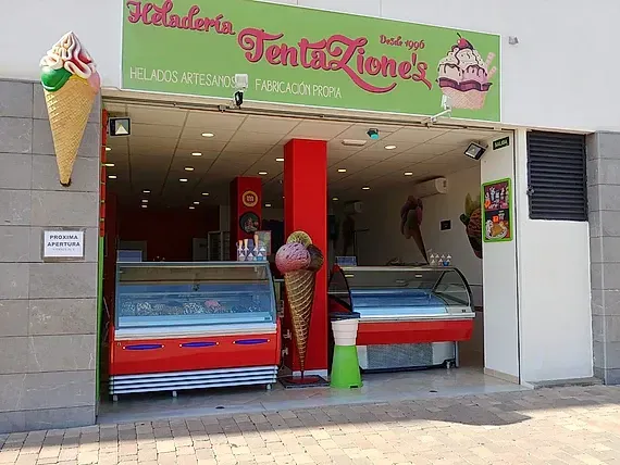 Un escaparate con un cartel que dice 'heladeria tentaciones'.