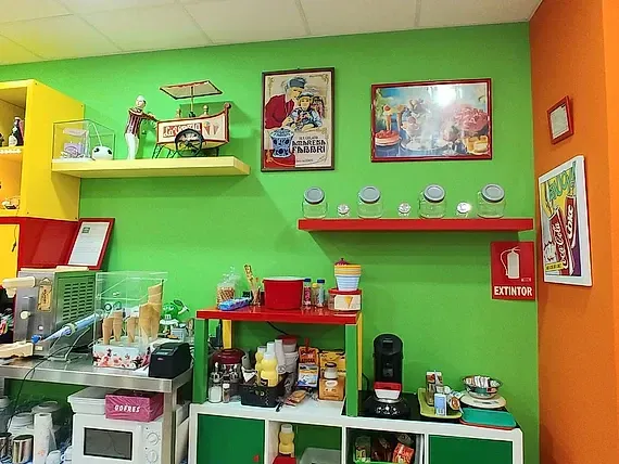 Una cocina con paredes verdes y un extintor rojo.