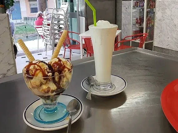 Dos tazones de helado y un batido en una mesa