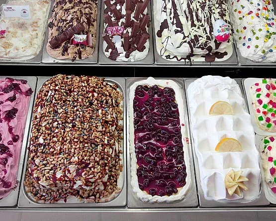 En un estante se muestran una variedad de sabores de helado.